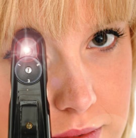 An optician looking through a device